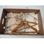 A box containing vintage table linens, huckaback towels and five vintage wooden coat hangers bearing