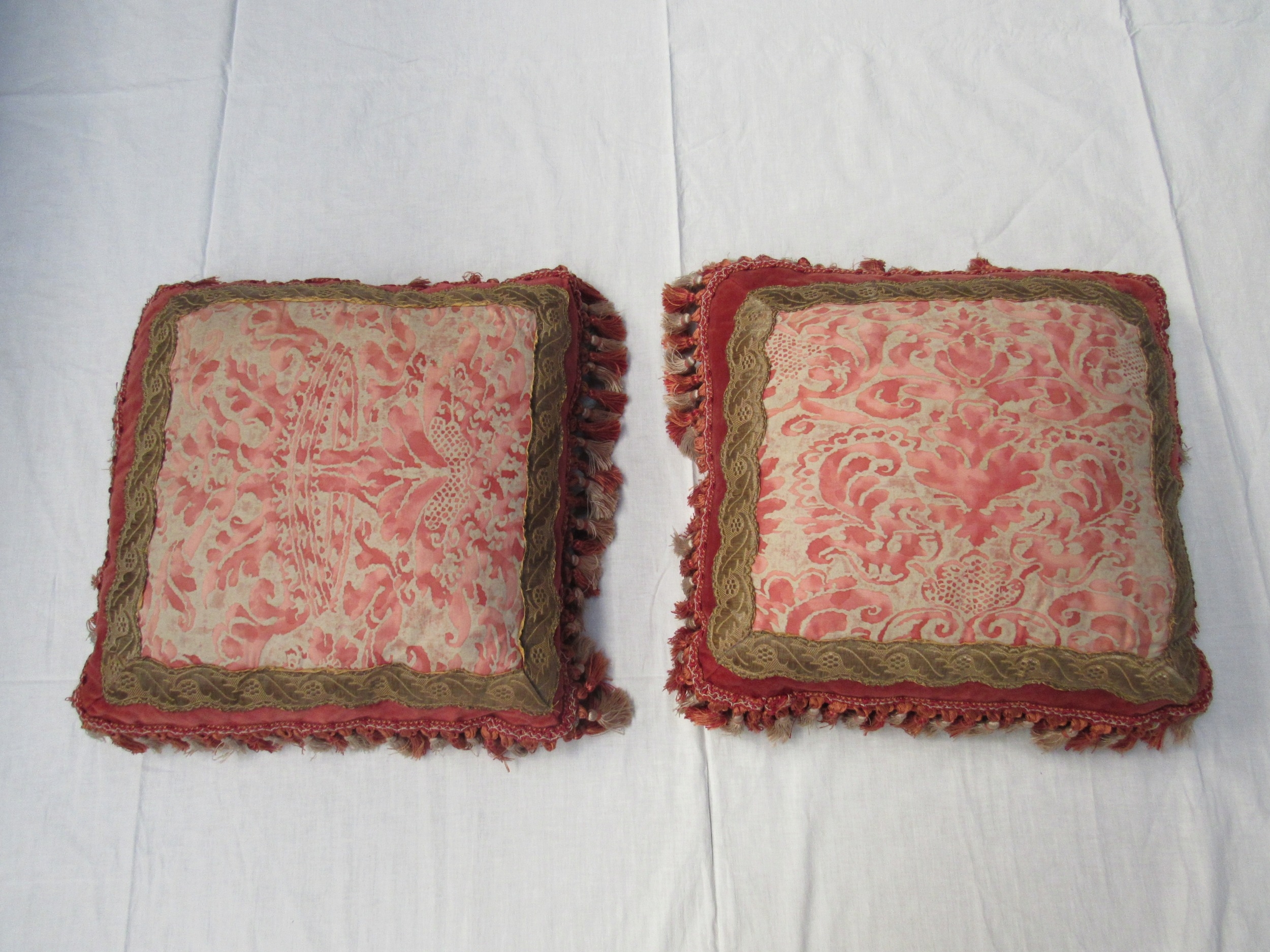 MARIANO FORTUNY: A pair of Fortuny fabric feather filled cushions in cream and coral, coronet