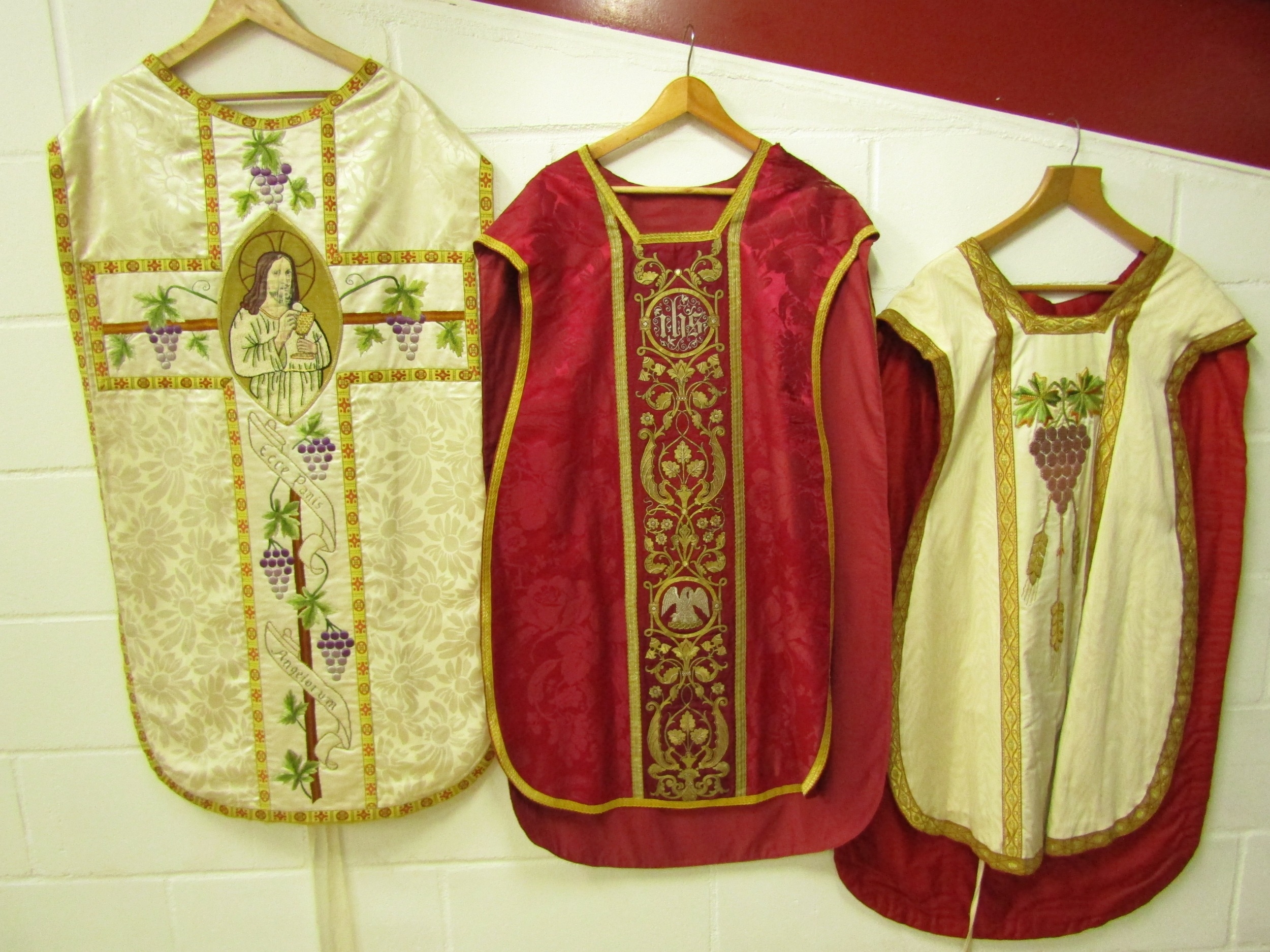 Three ecclesiastical tabards in silk, two with grape, wheat spray embroidery, the other has goldwork