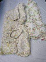 A pair of chintz pale lemon, green and white floral curtains with plaited tie-backs, a cotton