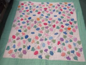 A vintage applique embroidered patchwork bedspread