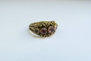 An unmarked gold ring set with five pink paste stones. Size M, 2.7g