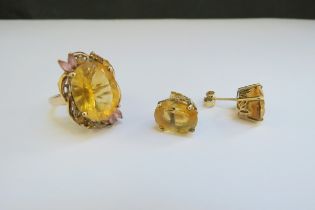 A 9ct gold ring with oval citrine in floral mount. Size N and a pair of citrine earrings,