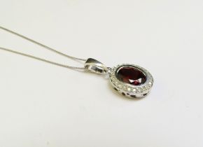 A white gold garnet and diamond cluster pendant hung on 9ct white gold chain, 46cm long, 2.4g