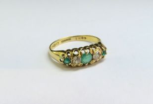 An 18ct gold five stone emerald and diamond ring. Size L, 2.2g