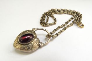 A Victorian heart shaped pendant with garnet cabochon, glass panel back, hung on chain, unmarked