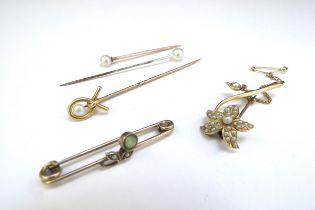 Two gold brooches one as a seed pearl set flower and a gold stick pin, unmarked, 7.6g