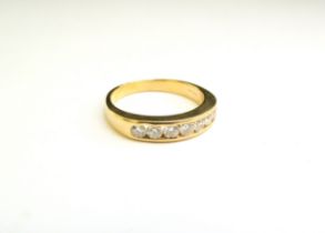 An 18ct gold ring with seven brilliant cut diamonds in channel setting. Size N/O, 4.2g