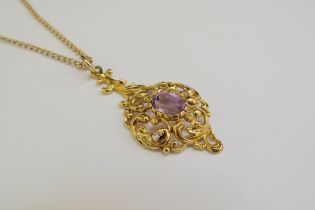 A 9ct gold chain 62cm long, hung with a scrolled foliate pendant with central amethyst, 4cm drop,