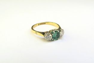 An emerald and diamond ring, the central square cut emerald 5mm x 5mm flanked by 0.22ct approx