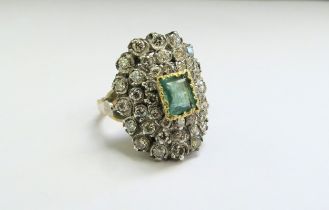 An emerald and diamond cluster ring, the central emerald 5mm x 8mm framed by diamonds 2ct approx