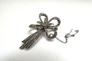 A star and bow form marcasite brooch with safety chain