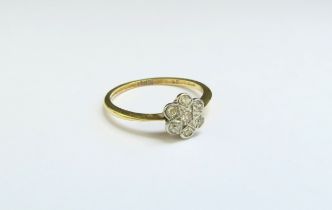 A diamond daisy ring, stamped 18ct. Size P, 2g