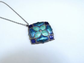 An Art Nouveau silver enamelled pendant in greens and blues 2.5cm x 2.5cm hung on a chain, clasp
