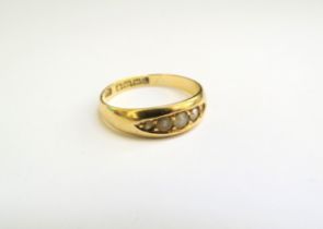 An 18ct gold ring set with seed pearls, one missing, 2.9g