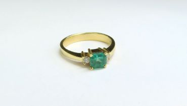 An emerald and diamond ring, the central square cut emerald 5mm x 5mm flanked by brilliant cut