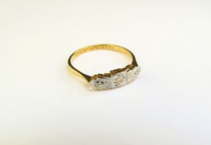 An art deco style illusion set three stone diamond ring, stamped 18ct/plat. Size O, 2g