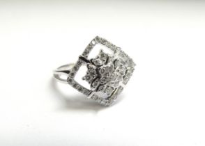 A platinum and diamond ring, diamond centre square halo framed by round bright cut diamonds, shank
