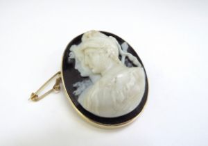 A cameo brooch depicting a Roman soldier and female side profile carved from a white/cream stone