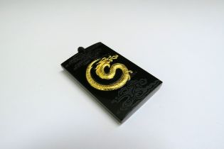 A black jade pendant of rectangular form, inset with 999.9 gold dragon, 4.5cm x 2.8cm