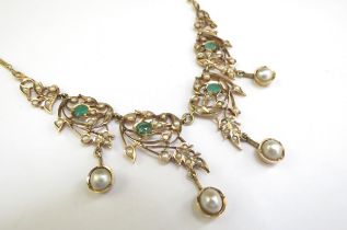An emerald and seed pearl studded necklet the central four panels hung with a pearl droplet, on