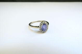 A 9ct white gold tanzanite and diamond cluster ring. Size M, 2.5g, with purchase receipt