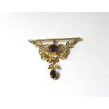 A gold bar brooch stamped 9ct suspended with a scroll and swag seed pearl and amethyst panel and