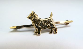 A 9ct gold bar brooch set with a gold terrier dog, 5.9g