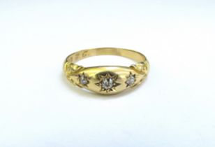 An 18ct gold ring set with three old cut diamonds in star settings. Size X, 5.7g