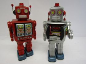A Japanese red tinplate battery operated robot with chest doors opening to reveal plastic guns,