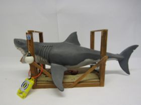 A large plastic model of a great white shark in wooden frame, 64cm long