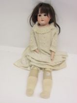 An early 20th Century Armand Marseille bisque head girl doll with brown wig, brown glass sleepy