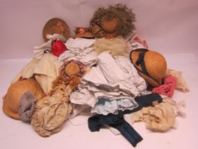 A large collection of dolls clothing including linen dresses, straw hats etc