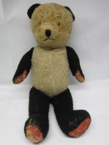 A vintage straw filled panda teddy bear with articulated limbs, 70cm tall