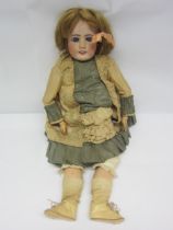 An early 20th Century French bisque head girl doll with blonde wig, striated blue glass fixed