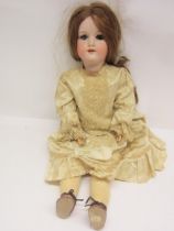 An early 20th Century Armand Marseille bisque head girl doll with strawberry blonde wig, striated