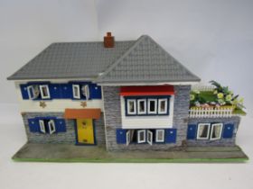 A wooden dolls house with sliding front, 43cm tall x 84cm wide