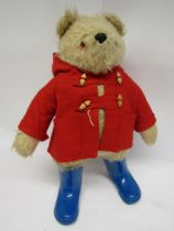 A vintage Gabrielle Designs Paddington Bear in original red duffle coat and blue wellington boots,