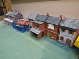 Seven weathered plastic model garden railway lineside buildings, each approx 32cm tall, and a