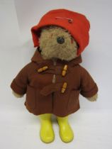 A vintage Gabrielle Designs Paddington Bear in original brown duffle coat, red hat and yellow