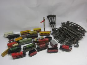 A collection of assorted playworn 0 gauge model railway locomotives, rolling stock and accessories