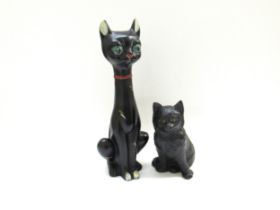 A large mid-century tall kitsch black cat pottery figurine and a Bretby Pottery black cat with glass