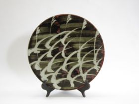 A Mashiko Pottery plate with resist ornamental grass detail and wide brush lined glaze. No pottery