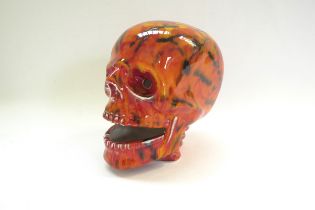 An Anita Harris Pottery skull with red and yellow glazes and black lines. Printed and signed marks