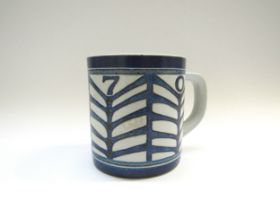 A Royal Copenhagen 1970 faience year mug designed by Dorte Schierup with 9255 silver roundel