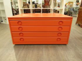 An orange painted four drawer Plan chest in Beech ply, with inset handles and set of four castors.