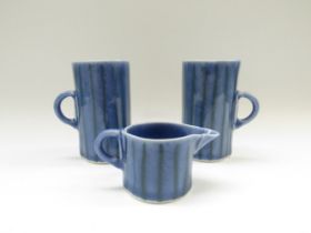 Two studio pottery mugs and a jug, each signed with potters AJC mark to base. Tallest 12cm