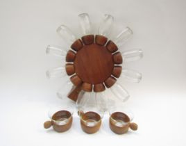 A revolving teak spice rack, 39cm diameter with 12 spice pots in clear glass and three wood and