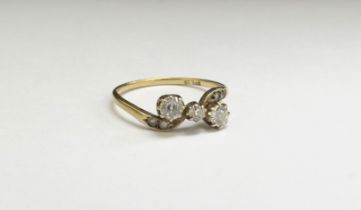 A three stone diamond crossover ring, 0.40ct approx total, stamped 18ct. Size O/P, 1.6g