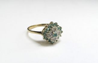 A 9ct gold diamond and emerald cluster ring. Size N/O, 2.4g
